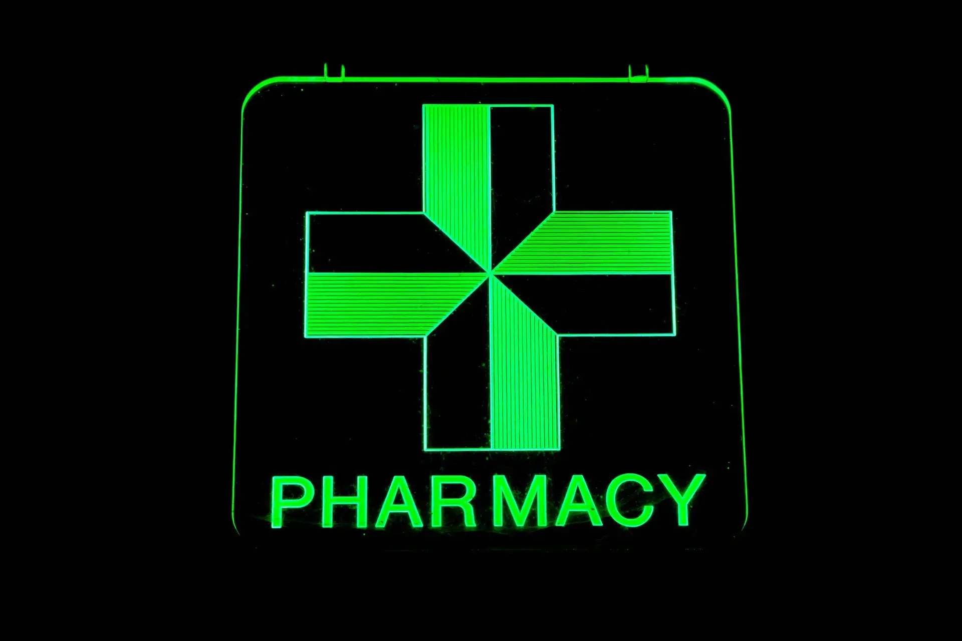 Green illuminated pharmacy cross sign